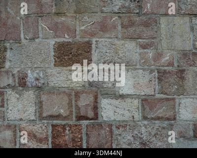Irregular natural stone masonry with varying colors, textures and joints. Suitable for backgrounds and text spaces Stock Photo