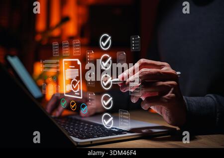 Business professional reviewing digital checklist documents on laptop, approval process, quality control, audit compliance, document verification, Stock Photo