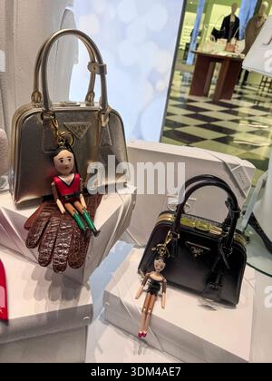 London, UK, 5 December 2025,  Luxury designer handbags Prada display on white pedestals with decorative doll fashion charms keychains attached featuri Stock Photo