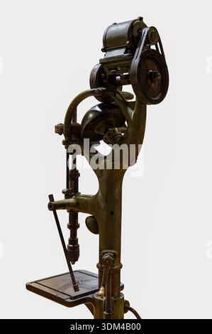 A cutout of an antique green vertical pillar drilling machine (drill press) with a belt-driven motor and exposed gears, isolated on a clean white back Stock Photo