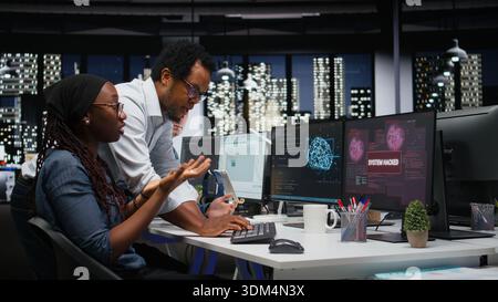 Team of programmers in office working together to block hacker intrusion. Teamworking IT company cybersecurity division colleagues coordinating incident response for scammer attacks Stock Photo