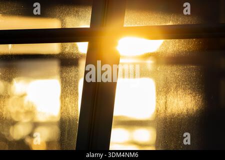 Sunlight shining through a window creates a warm backlit atmosphere with soft glare and natural light, forming an abstract and minimalist indoor scene Stock Photo