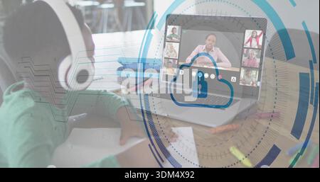 Studying child wearing white headset and green shirt at study table, on laptop, cloud-lock graphics Stock Photo