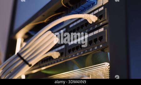 Ethernet cables connecting to a network switch in a data center rack Stock Photo