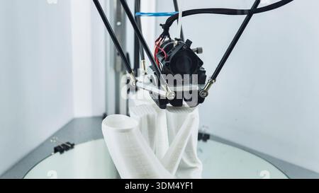 3D printer creating a white plastic prototype on a build platform Stock Photo