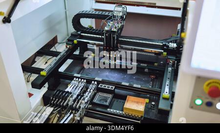 Pick and place machine assembling electronic components in SMT manufacturing facility Stock Photo