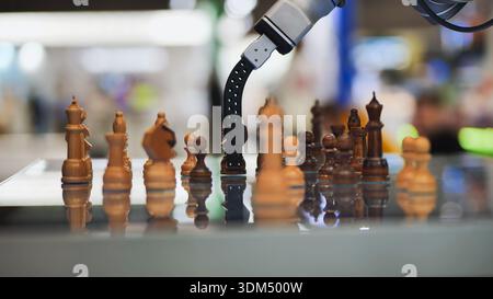 Robot arm moving chess piece during game, concept of AI, strategy, and automation Stock Photo