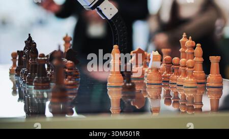 Robotic arm playing chess, demonstrating artificial intelligence and strategic thinking Stock Photo