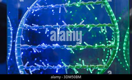Glowing DNA helix structure with blue and green LED lights for science and technology concept Stock Photo