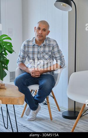 Man posing for a portrait in a casual plaid shirt and jeans Stock Photo