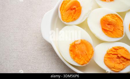 Hard boiled eggs peeled and cut in plate Stock Photo