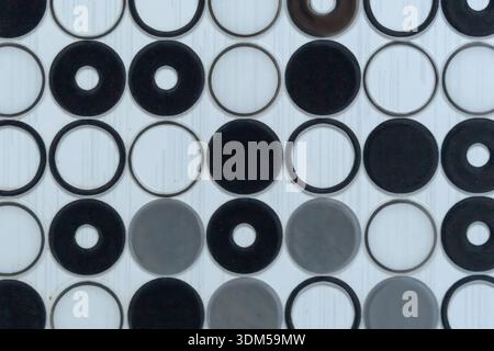 Abstract geometric pattern of black, white, and gray circular tiles. Modern mosaic texture for interior flooring or wall design Stock Photo