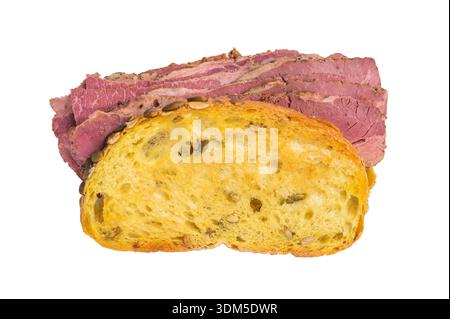 Gourmet pastrami brisket sandwich made from thin sliced cured deli meat and seed crusted bread on a bright white studio background Stock Photo