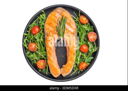 Grilled salmon steak served on arugula and cherry tomatoes in a black plate against a bright gray background for clean modern food imagery Stock Photo