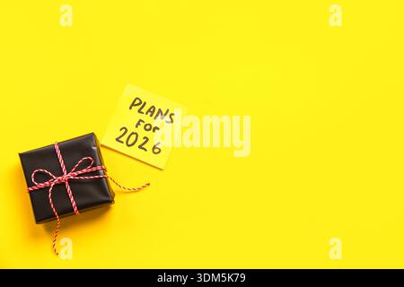Sticky note with goals for 2024 and gift box on yellow background Stock Photo
