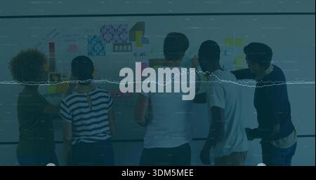 Reviewing five coworkers pointing at writable wall in office, showing Post-it waveform overlay Stock Photo