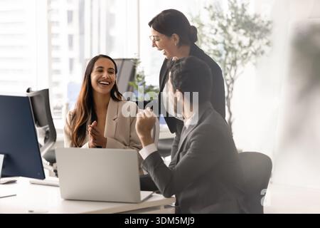 Three diverse laughing team members having fun during teamwork Stock Photo