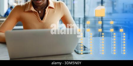 Person works on laptop with folder structure diagram in a modern setting Stock Photo