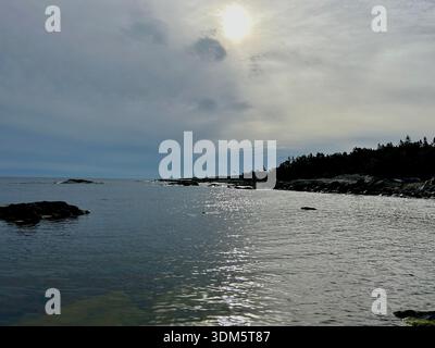Dramatic sky over calm Baltic Sea with rocky pine-covered headland along the Swedish coastline Stock Photo