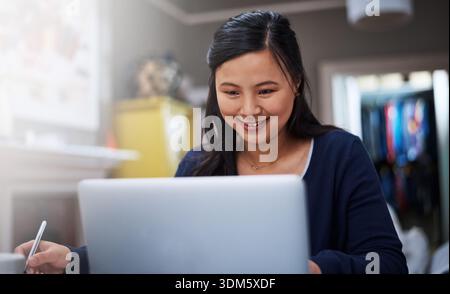 Laptop, woman and entrepreneur in office with reading information for startup business. Happy, writing and female magazine editor with online article Stock Photo