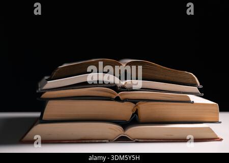 Old library, an open Bible lay on the table, its holy pages of scripture illuminated in the dark room. bible, holy, dark, old, open, library, pages, s Stock Photo