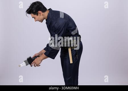 Electrician using screwdriver on floor in studio Stock Photo