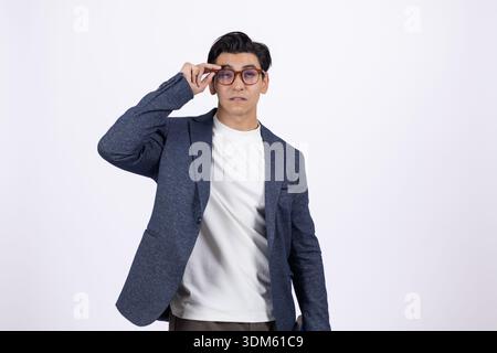 Man in white shirt and blazer adjusting his glasses Stock Photo