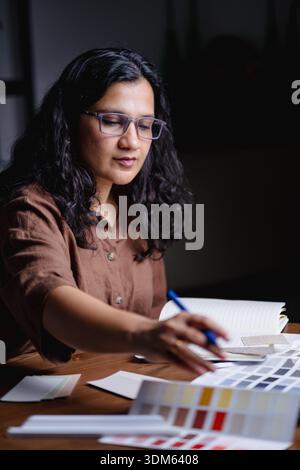 Interior designer working late night in studio with samples and materials Stock Photo