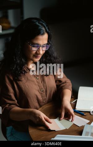 Interior designer selecting color palette with fabric and wood samples at night Stock Photo