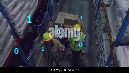 Walking 2 hardhat staff pushing pallet jack carrying boxes in warehouse aisle binary digits showing Stock Photo