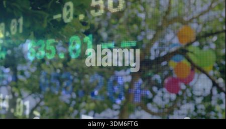 Displaying translucent pixel grid with green blue numerals over park foliage, bright balloons Stock Photo