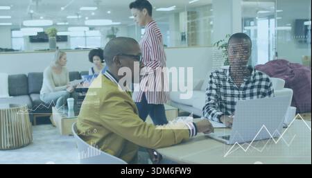 Talking two men in mustard jacket and checked shirt viewing laptop charts at lounge with overlays Stock Photo