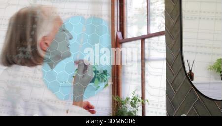 Applying senior woman in robe applying lipstick at vanity with teal overlay and mirror, copy space Stock Photo