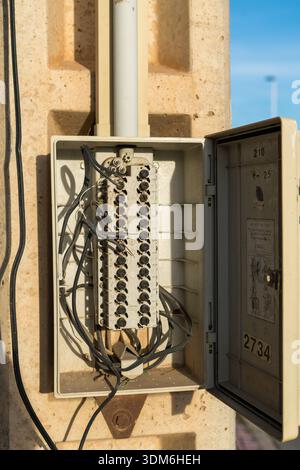 junction box of an open electrical system with dangling wires, white ...