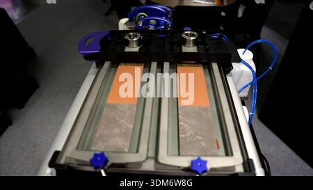 Industrial precision machine applying mechanical stress to two material samples, ensuring quality control and product durability Stock Photo