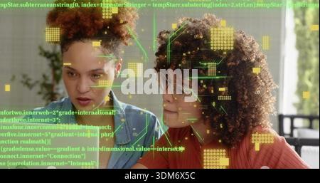 Leaning pair studying code in home-office on PC, wearing blue shirt, rust top, glasses, AR overlay Stock Photo