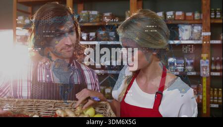 Inspecting staff checking basket produce in shop wearing aprons holding blue-pen digital-overlay Stock Photo