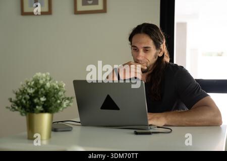 Man concentrating on laptop working remotely from home Stock Photo