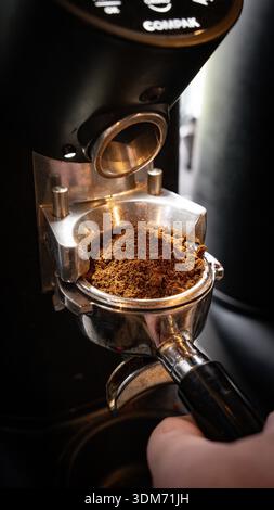 Professional coffee grinder inside an independent specialty coffee shop in Hampshire, UK. Close-up detail of espresso grinding equipment Stock Photo