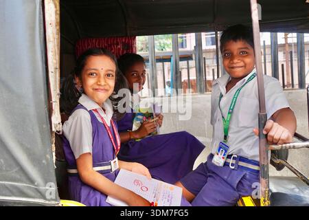 Indian school children wearing school uniform smiling in auto rickshaw , Trichy, India Stock Photo