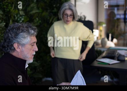 Senior business colleagues discussing documents while collaborating in a modern office environment Stock Photo