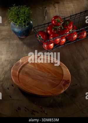 Empty wooden plate on a dark rustic table - cooking ingredients still life Stock Photo