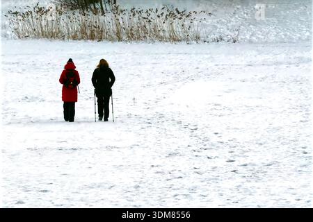 Two people walking in a snowy winter landscape Stock Photo