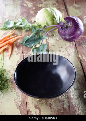 Fresh Organic Vegetables and Empty Black Bowl on Rustic Wooden Table Stock Photo