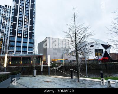 Manchester, UK - January 21, 2026: Contemporary Manchester waterfront with tall glass buildings, a geometric white structure, and calm riverfront. Avi Stock Photo