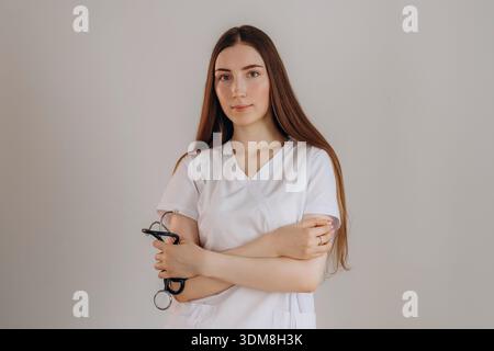 Standing with arms crossed. Female doctor is in the studio. Stock Photo
