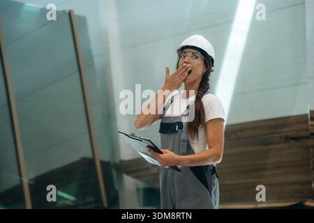 Shocked and funny facial expression. Woman is in the window making factory. Stock Photo