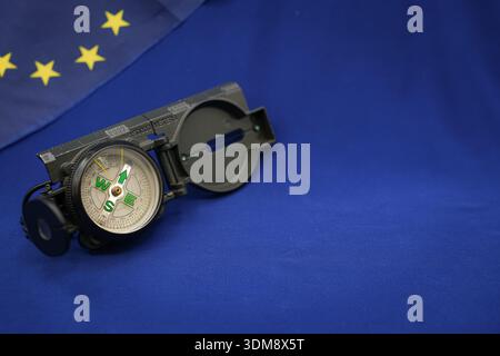Military Compass on a Blue Background. European Union Flag. Shallow Depth of Field. Copy Space. Stock Photo