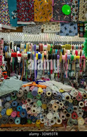 Large and colourful selection of needlework and sewing materials and fabrics including cottons, threads, bolts of fabric, ribbons and accessories. Stock Photo