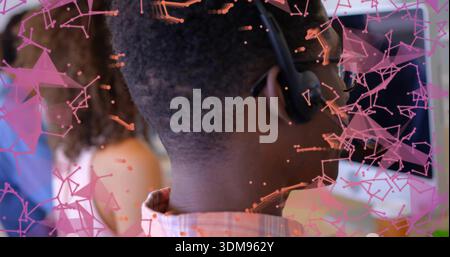 Answering African American man in checked shirt handling call at call center, headset mic overlay Stock Photo